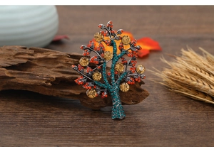 Detailed close-up of tree brooch with colorful rhinestones on a vintage autumn background