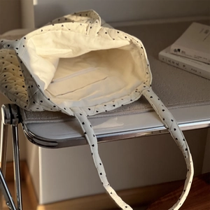 Détail du sac cabas matelassé en velours avec intérieur spacieux et poche zippée