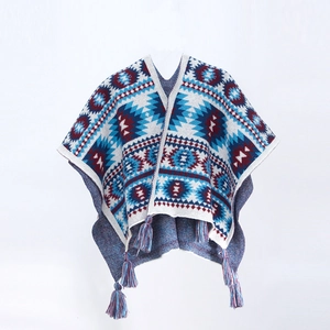 Ethnic bohemian knit poncho with blue red geometric patterns and fringe tassels