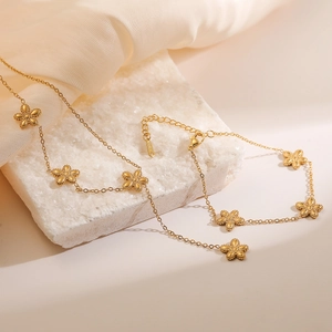 Elegant gold plated stainless steel floral pendant necklace on a decorative stone