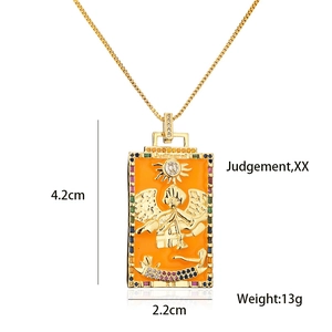 Detail view of gold Tarot card pendant necklace with orange enamel and colorful zircons