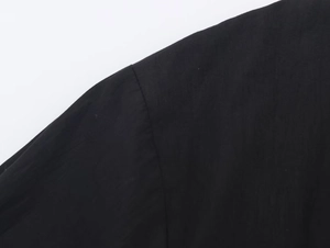 Close-up of shoulder seam and fine poplin fabric texture on a black casual shirt