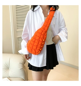 Gros plan du sac bandoulière matelassé orange vif avec détails de cordon réglable