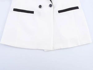 Détail d'ensemble blazer blanc montrant les boutons noirs et les liserés de poches