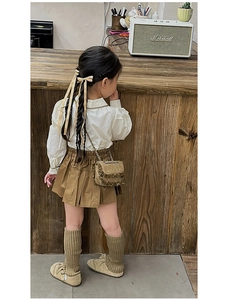 Girl's brown textured mini crossbody bag with gold chain strap for autumn winter fashion