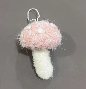 Dettaglio di fungo di peluche rosa fatto a mano con pois bianchi per decorazioni natalizie