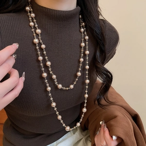 Close-up of elegant double-layer pearl and crystal necklace on brown sweater