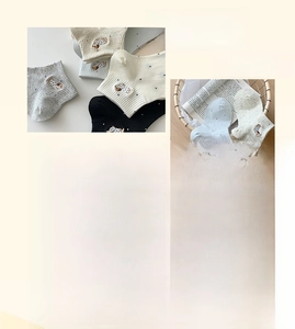 Detail of soft combed cotton socks with cute dog embroidery and stylish polka dot patterns