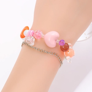 Detalle de pulsera de doble capa con cuentas de resina de colores y cadena plateada
