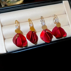 Close-up of red acrylic petal tassel earrings with zircon studs in gold and silver