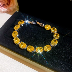 Close-up of elegant silver bracelet with yellow oval crystals on black velvet box