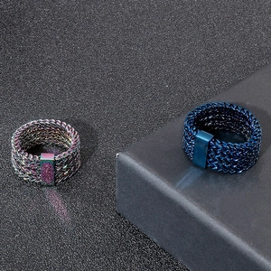 Men's punk rock rainbow and blue braided stainless steel rings on a dark display stand