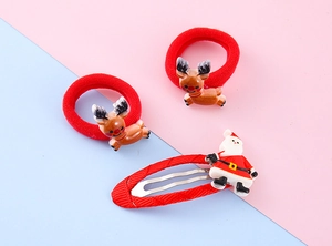 Detail of Christmas hair clips and elk elastic bands on pastel background for girls