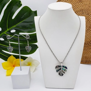 Detail of monstera leaf jewelry set with colorful abalone shell on a mannequin