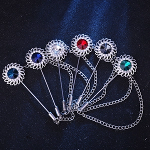 Close-up of six colorful sunflower lapel pins with rhinestones and metal chain tassels