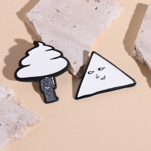 Minimalist white and black enamel pins with creative geometric figure designs on stone