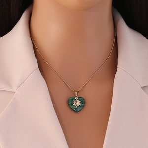 Golden heart necklace with green malachite pendant and sparkling star detail on a model