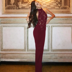 Detailed view of burgundy lace halter neck and open back on a slim fit evening gown