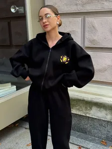 Detail of lion shield embroidery on black hooded sports sweatshirt and matching sweatpants