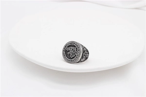 Macro detail of vintage silver wolf head ring with runic characters and oxidized finish