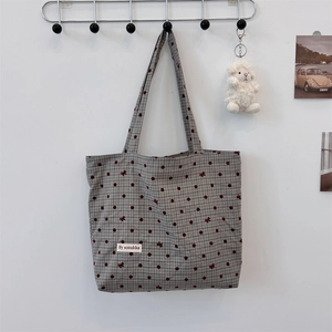 Détail du sac en toile gris à pois bordeaux et motifs de petits nœuds