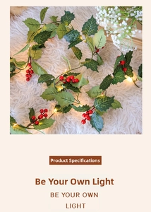 Detail of Christmas artificial vine with red berries, holly leaves and warm LED lights