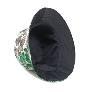 Detail of floral bucket hat showing green leaf print and reversible black lining fabric