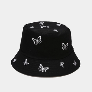 Close-up of white butterfly embroidery on a black canvas reversible bucket hat