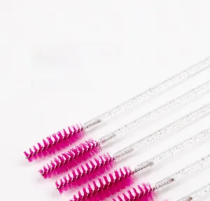 Macro view of crystal handle eyelash brushes with glitter handle and spiral pink bristles