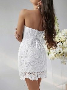 Detailed view of the lace-up back design on a white floral lace strapless dress