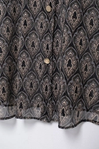 Detailansicht der Paisley-Chiffonbluse mit goldenen Knöpfen und dunklem Muster