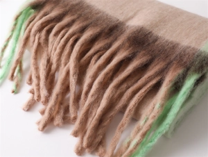 Detail shot of the beige and mint green gradient fringe tassels on soft cashmere-feel scarf