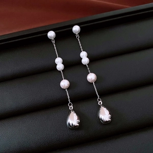 Detail of French vintage pearl drop earrings with silver waterdrop pendants on black leather
