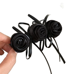 Pince à cheveux élégante avec roses en satin noir et longs rubans sur fond blanc