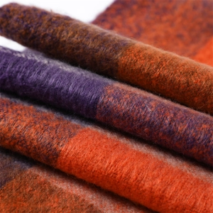 Detailed macro shot of thick plush checkered scarf in orange, purple, and brown tones