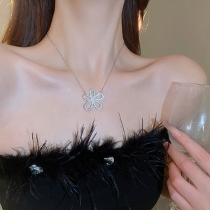 Close-up of sparkling flower pendant necklace worn by a model for elegant styling
