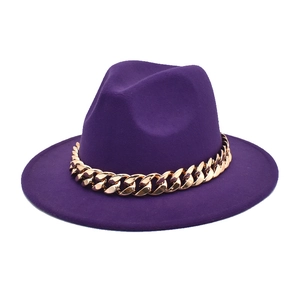 Detail of purple fedora hat featuring a bold gold chain band on a minimalist flat brim