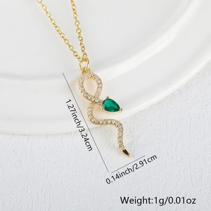 Macro shot of 18K gold snake pendant with cubic zirconia and green gemstone details