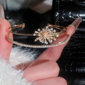 Close-up of starburst zircon and pearl detail on a rose gold double-layered cuff bracelet