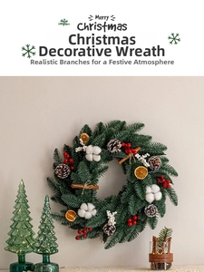 Christmas wreath with pine cones, red berries and cinnamon sticks on a wall