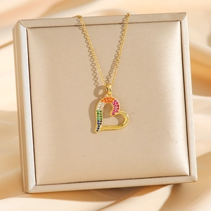 Collier cœur doré avec cristaux colorés sur un écrin à bijoux en satin de champagne