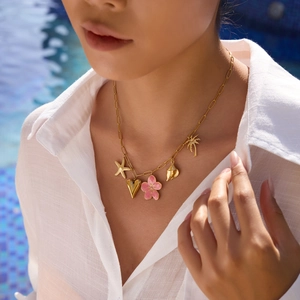 Close-up of gold stainless steel necklace with peach blossom, starfish and shell charms