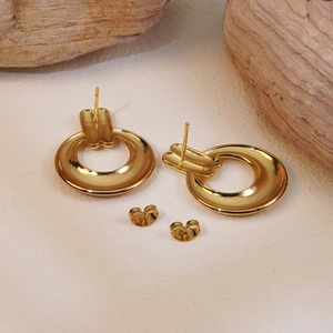 Minimalist polished gold round hoop earrings with butterfly backs on natural wood