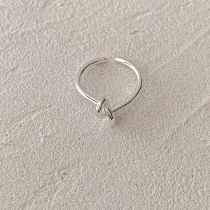 Minimalist 925 sterling silver knotted ring with adjustable open design on stone surface