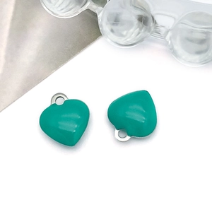 Detail showing two silver heart pendants with bright turquoise enamel oil drop finish