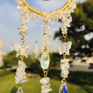 Close-up of golden moon suncatcher with natural crystal stones and butterfly pendants