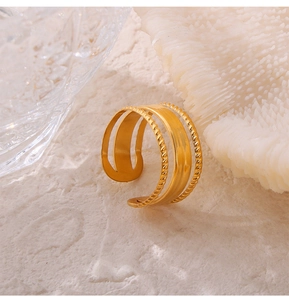 Detail of gold-plated triple-layer open ring featuring twisted rope textures and matte finish