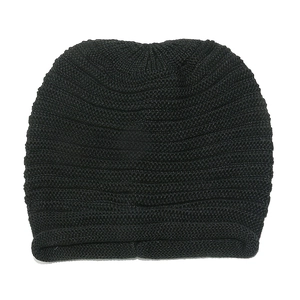 Detailed view of the thick ribbed knit texture and folded cuff of a black winter beanie