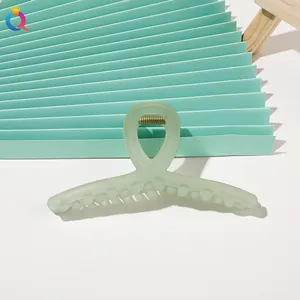Detail shot of mint green matte hair claw clip with crisscross design and metal spring