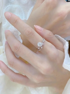 Close-up of sparkling moissanite engagement ring with criss-cross band on hand